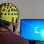 design a closed-loop brain-computer interface that autonomously modulates human emotions in real-time to match any desired psychological state